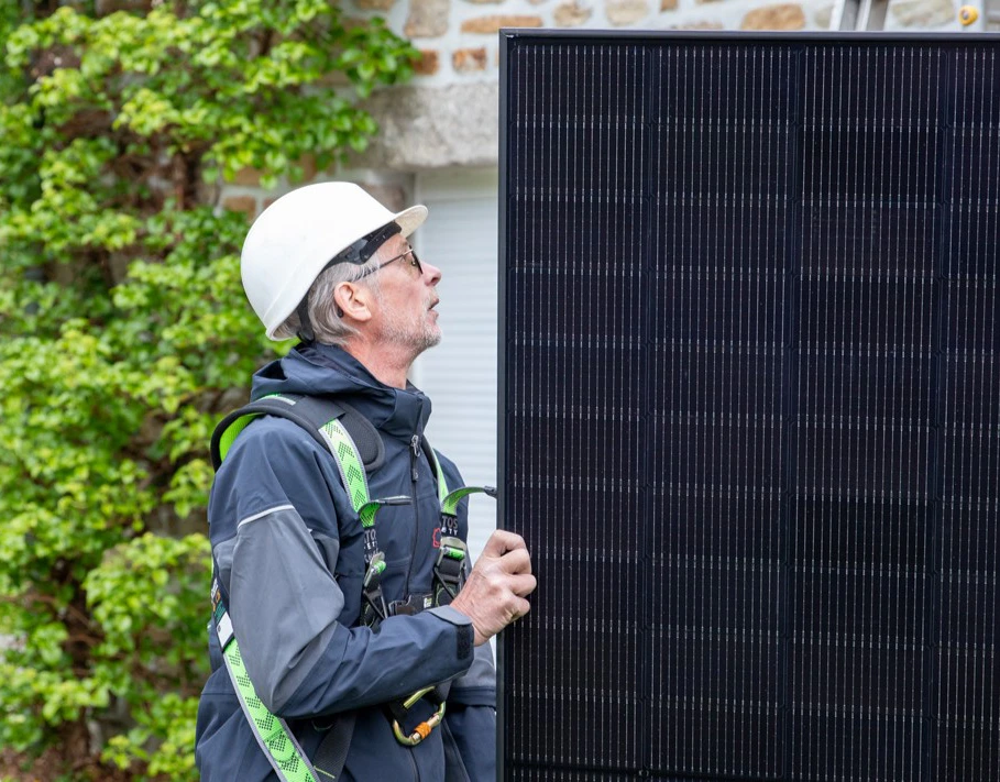 Techicien manipulant un panneau solaire sur un chantier d'installation HomeServe