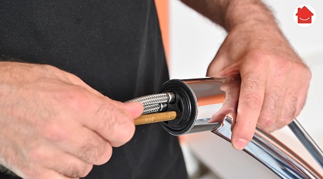 Mains assemblant un flexible de raccordement de robinet chromé