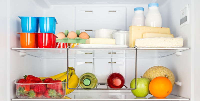 Intérieur d'un réfrigérateur bien rempli de fruits et produits frais