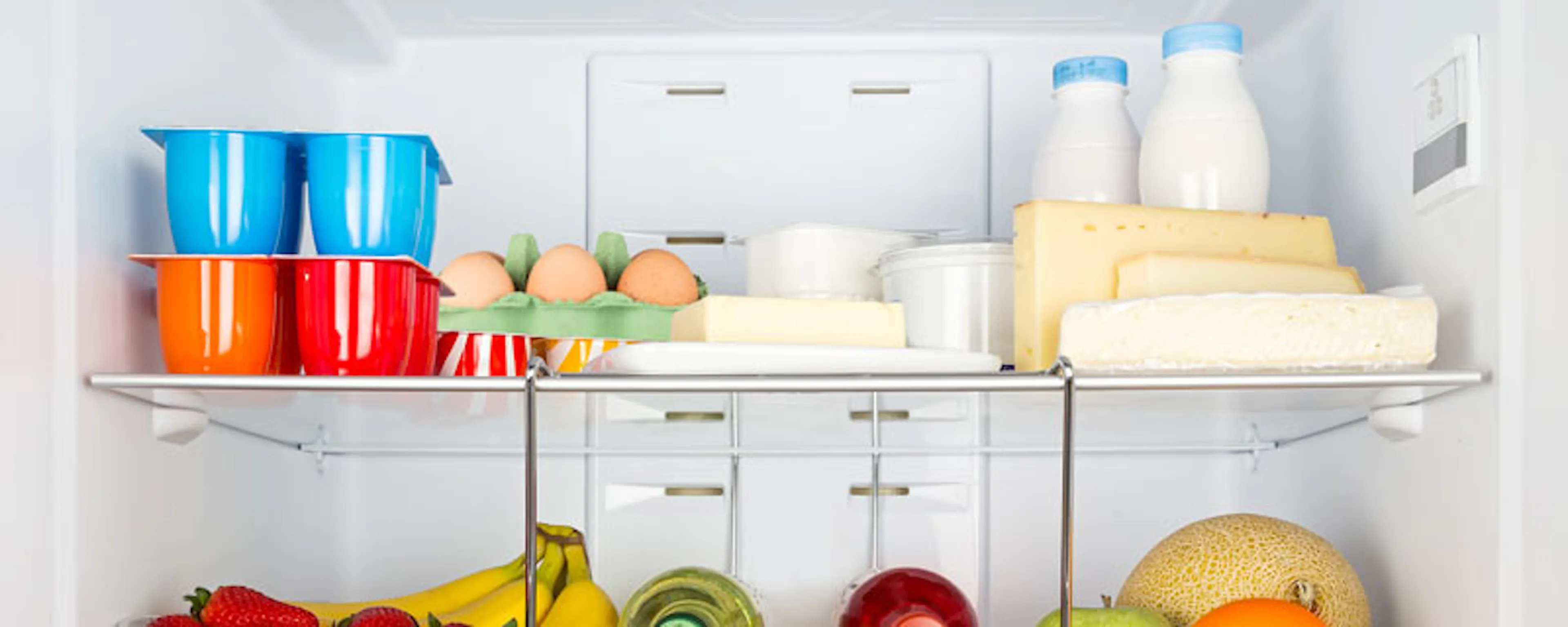 Intérieur d'un réfrigérateur bien rempli de fruits et produits frais