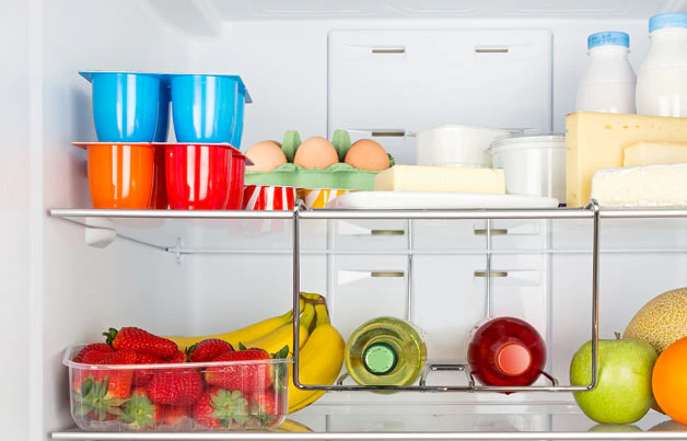 Intérieur d'un réfrigérateur bien rempli de fruits et produits frais