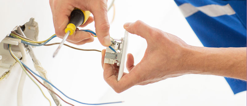 Électricien connectant des fils électriques à une prise murale