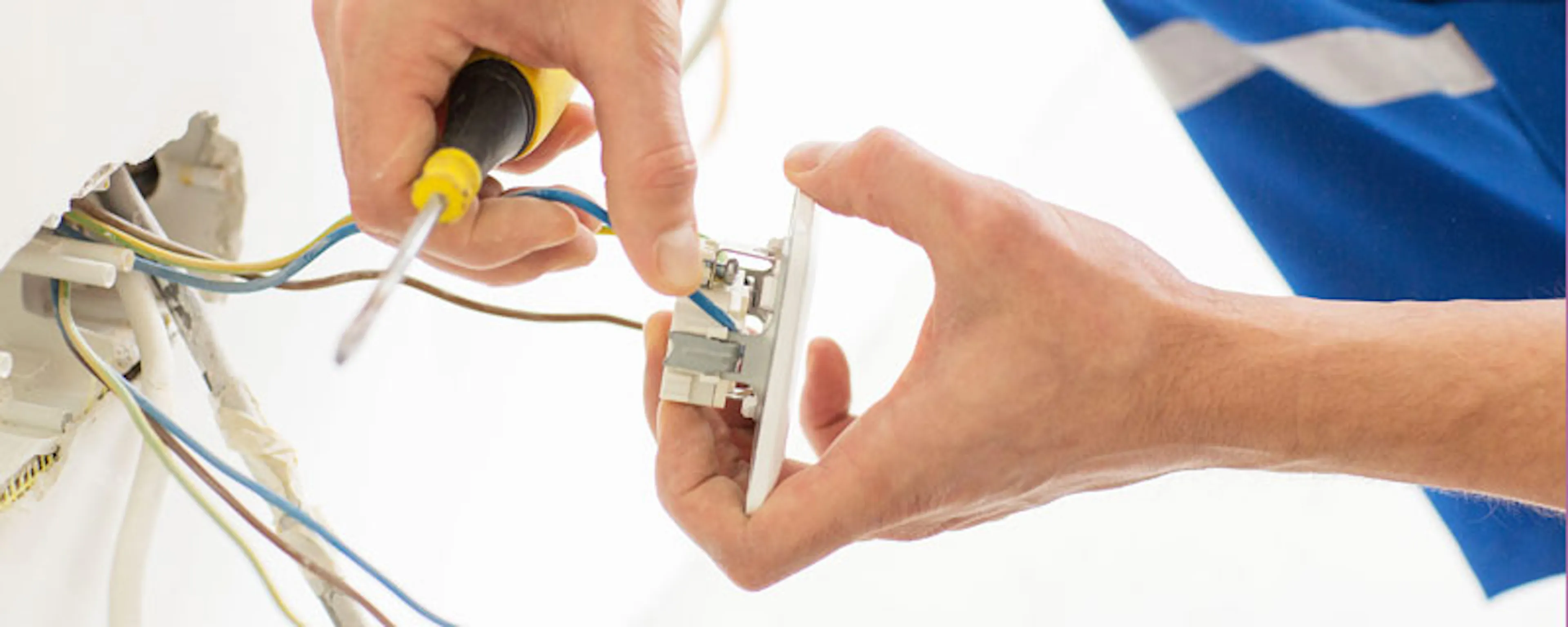 Électricien connectant des fils électriques à une prise murale