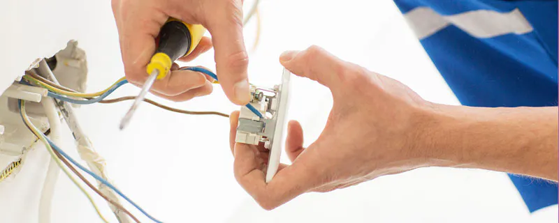 Électricien connectant des fils électriques à une prise murale