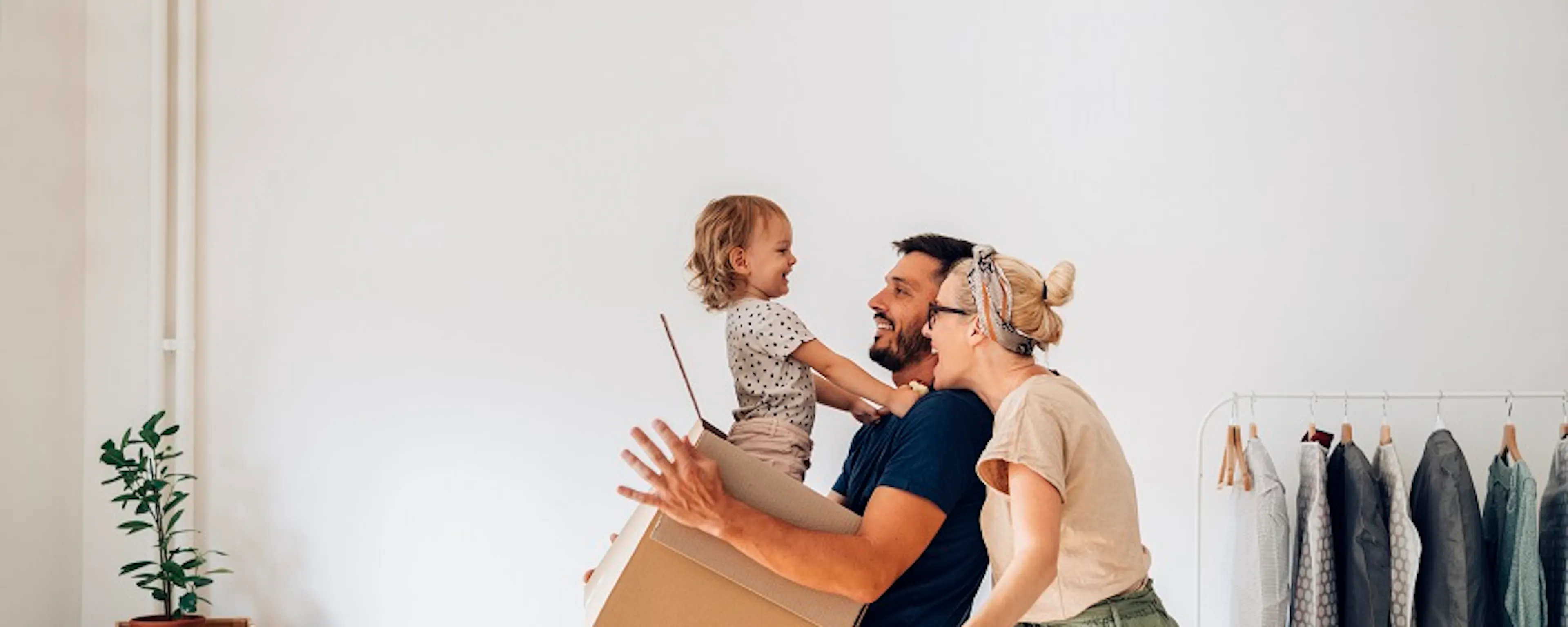 Famille joyeuse avec enfant jouant avec un carton lors d'un déménagement