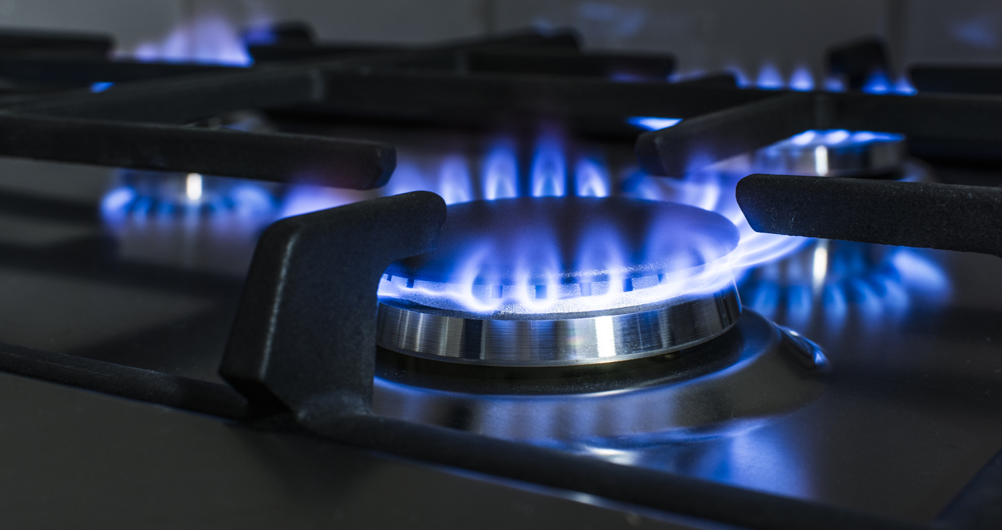 Brûleur à gaz allumé avec flamme bleue sur plaque de cuisson