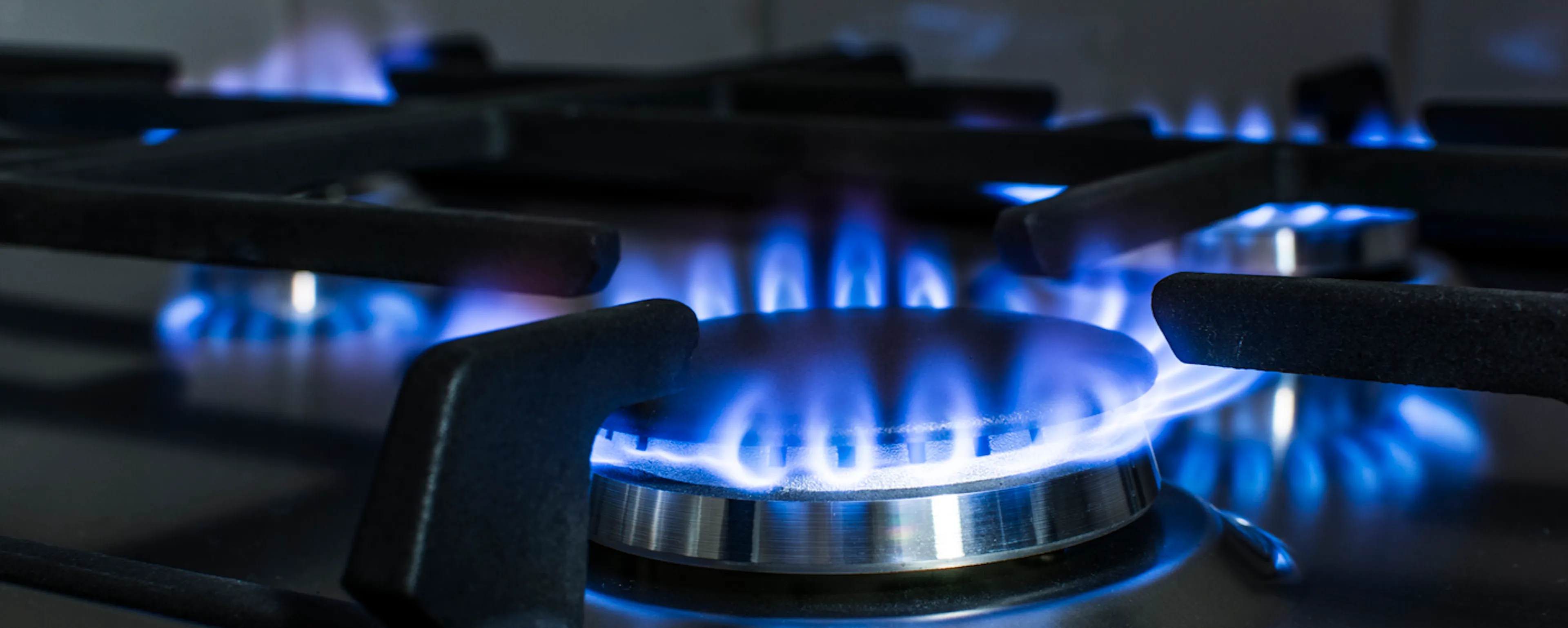 Brûleur à gaz allumé avec flamme bleue sur plaque de cuisson