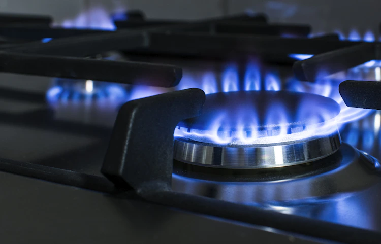 Brûleur à gaz allumé avec flamme bleue sur plaque de cuisson
