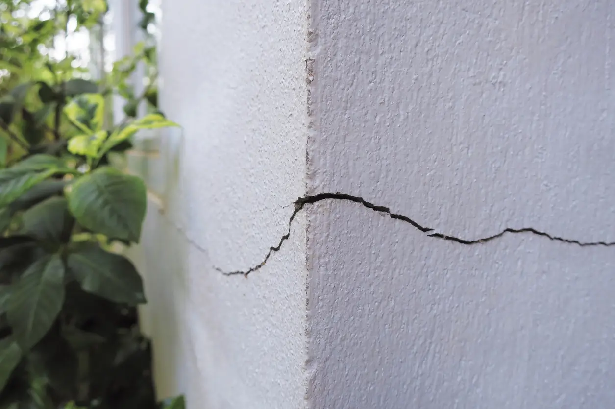 Fissure verticale sur un mur blanc extérieur