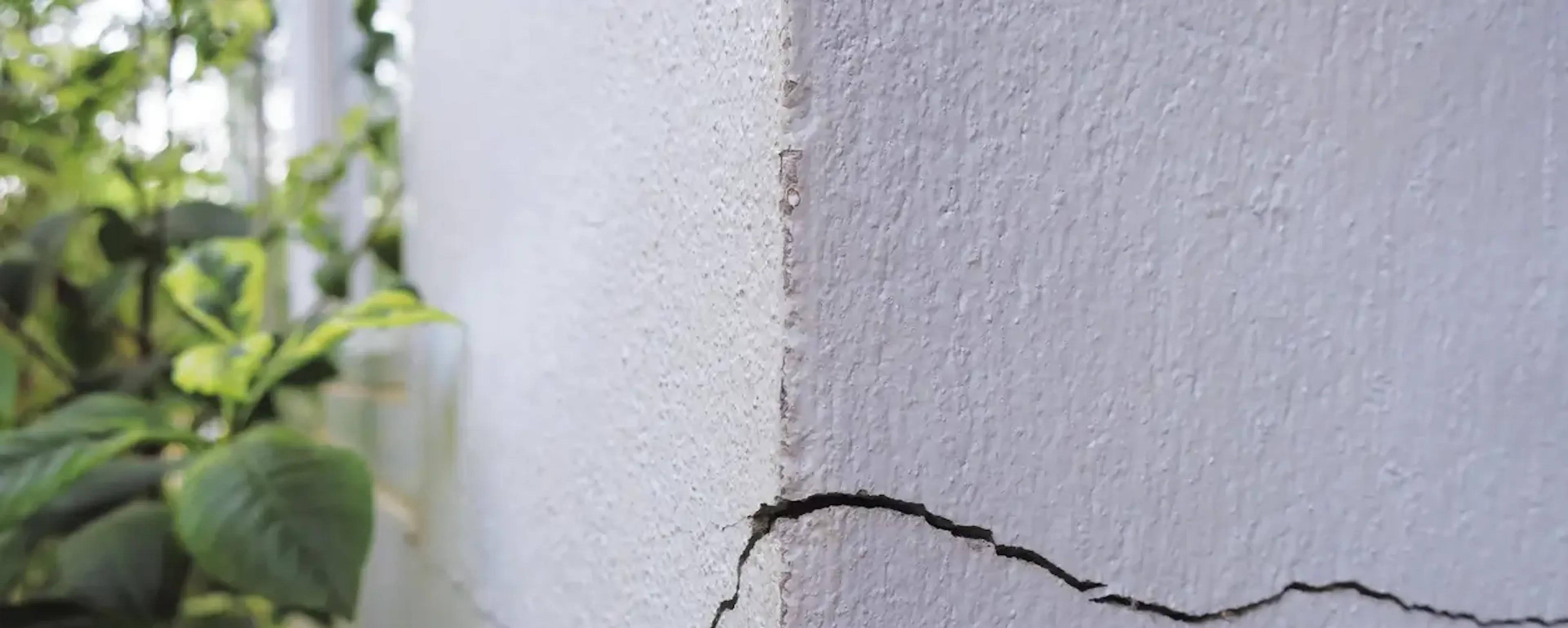 Fissure verticale sur un mur blanc extérieur