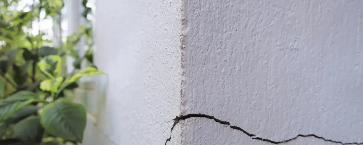 Fissure verticale sur un mur blanc extérieur
