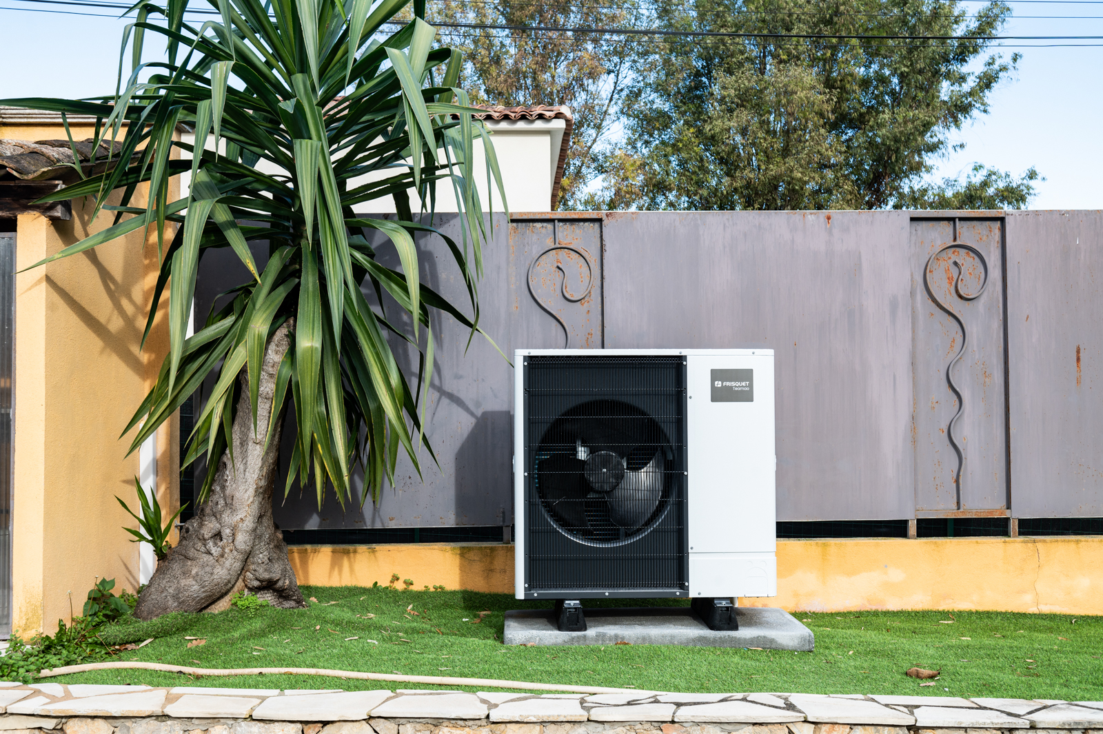 Unité extérieure de pompe à chaleur installée dans le jardin d'une maison individuelle par une entreprise HomeServe dans les Alpes-Maritimes