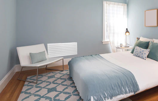Chambre lumineuse aux murs bleus avec grand lit blanc et parquet