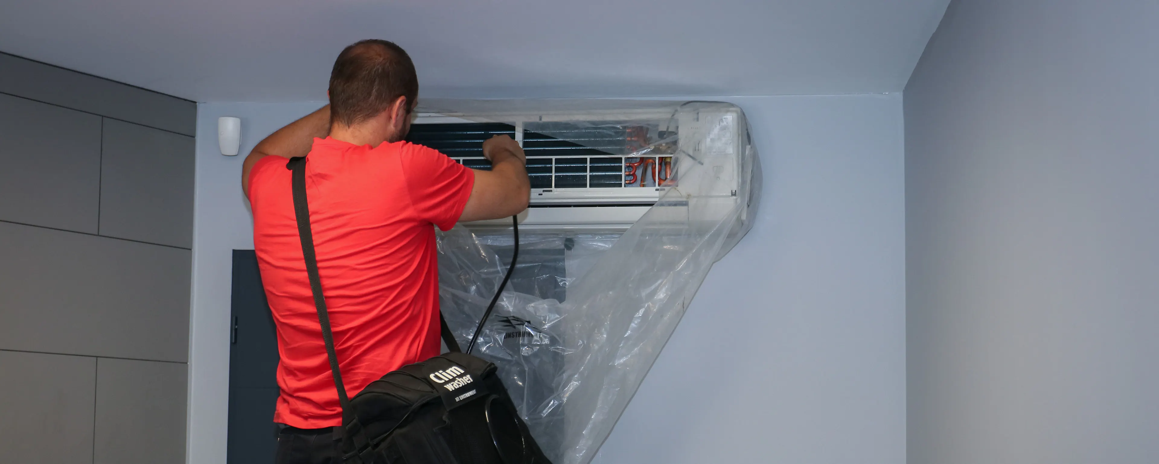 Technicien HomeServe nettoyant et entretenant une climatisation