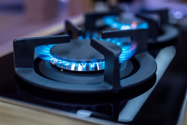 Flammes bleues allumées sur les brûleurs d'une gazinière
