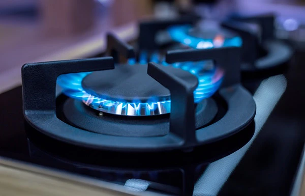 Flammes bleues allumées sur les brûleurs d'une gazinière