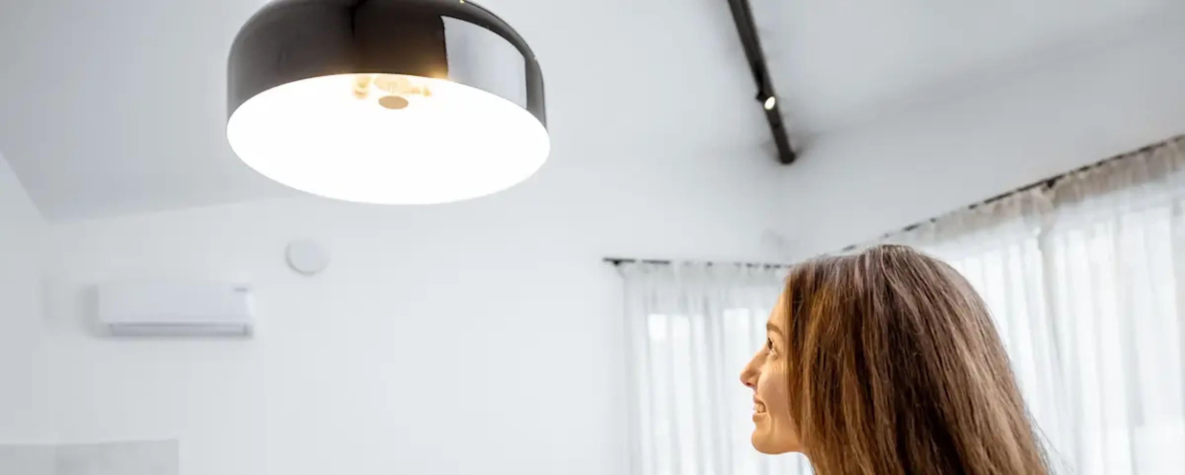 Femme pilotant une climatisation via une tablette dans son salon