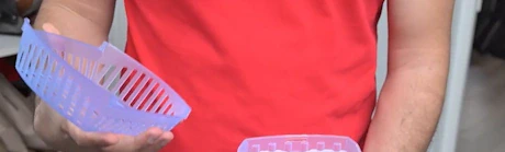 Homme tenant deux paniers en plastique colorés dans les mains