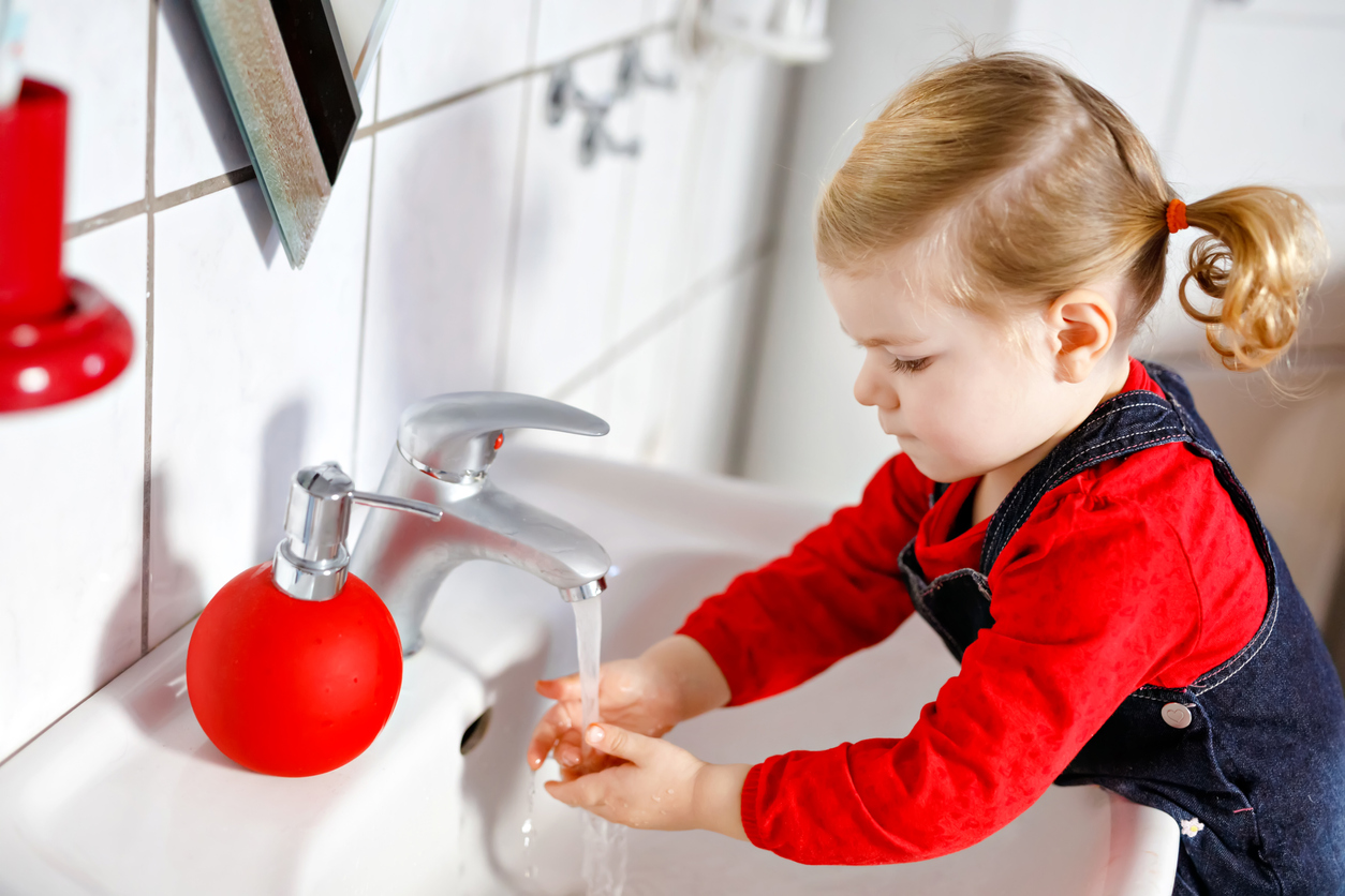 Petite fille se lavant les mains au lavabo de salle de bain