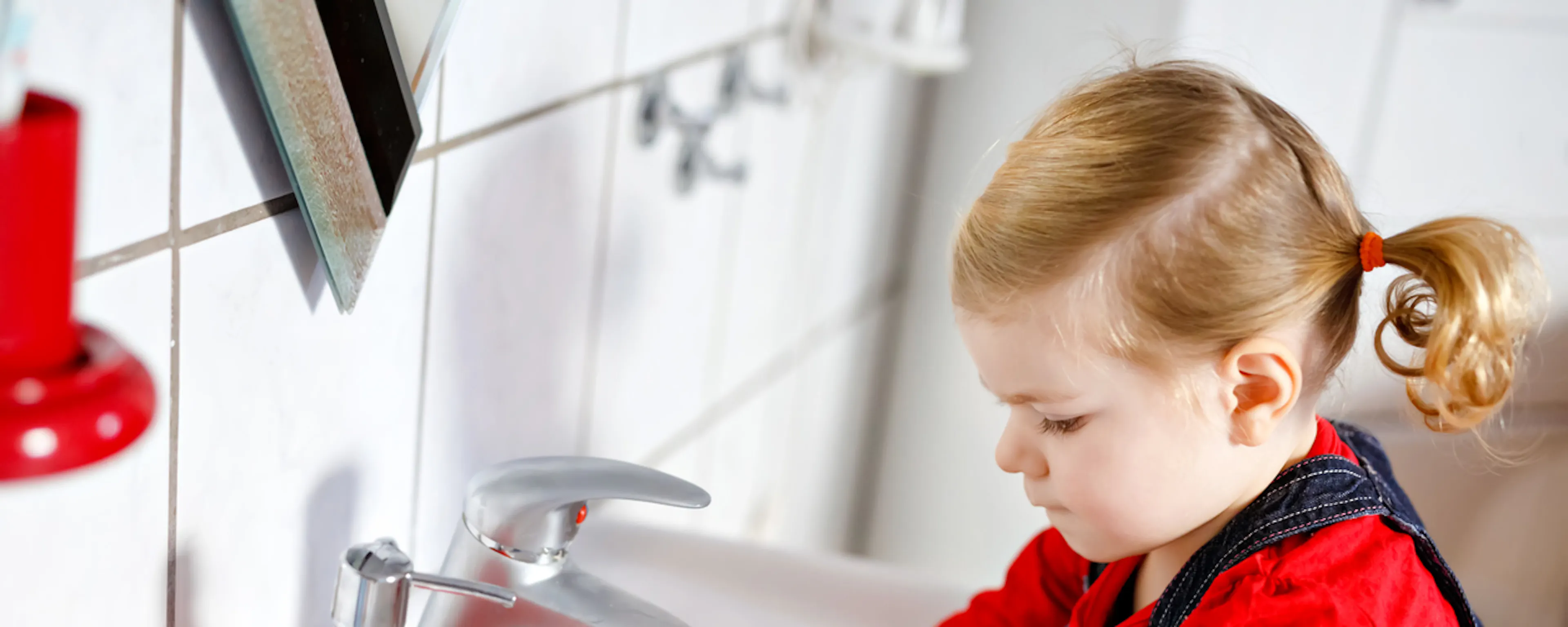 Petite fille se lavant les mains au lavabo de salle de bain