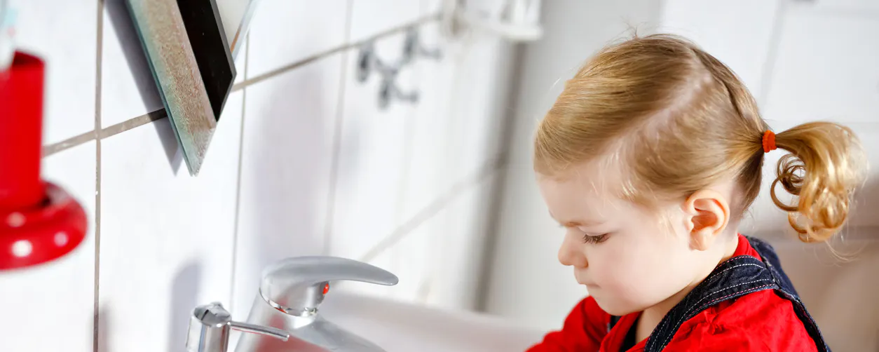 Petite fille se lavant les mains au lavabo de salle de bain