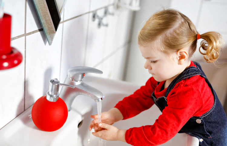 Petite fille se lavant les mains au lavabo de salle de bain