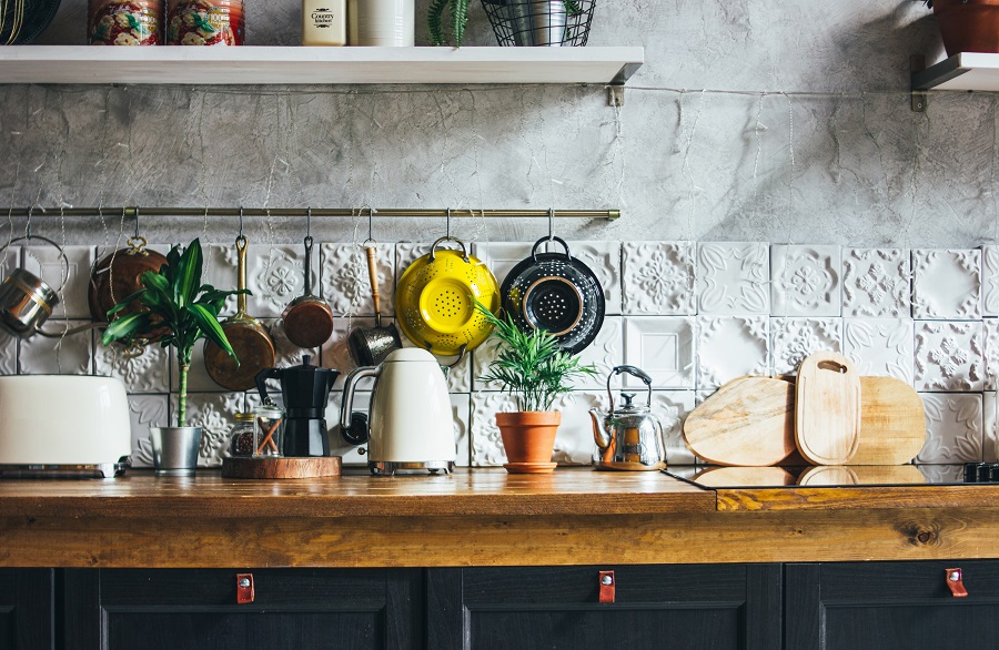 Plan de travail en bois avec ustensiles et plantes dans une cuisine rustique