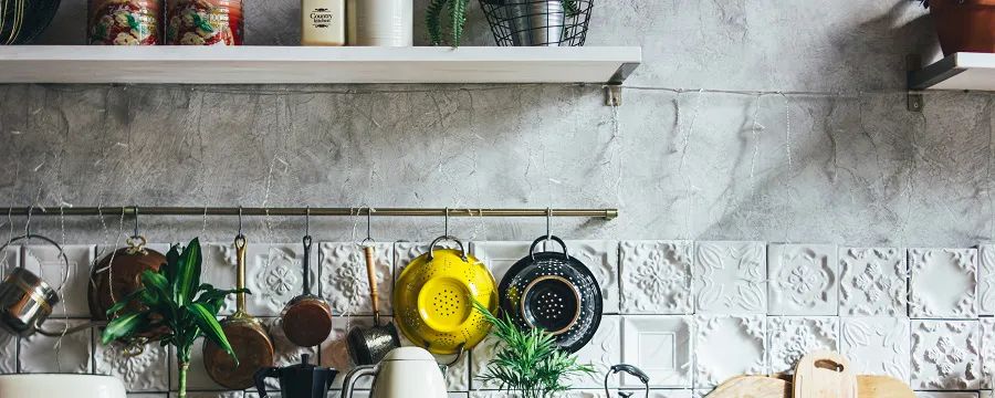 Plan de travail en bois avec ustensiles et plantes dans une cuisine rustique