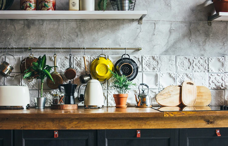 Plan de travail en bois avec ustensiles et plantes dans une cuisine rustique