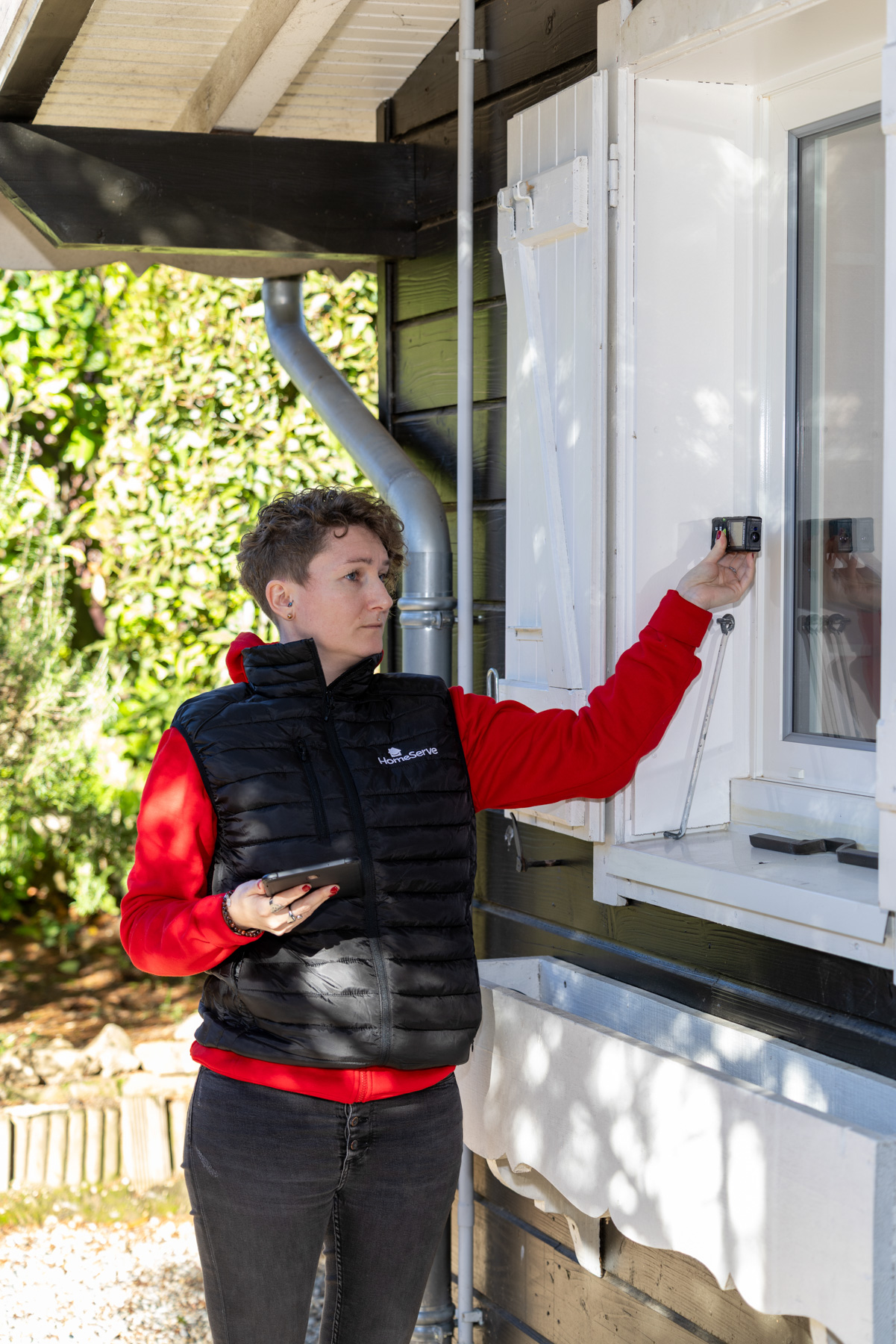 Conseillère technique HomeServe prenant les mesures d'un cadre de fenêtre en vue de l'isolation de la maison