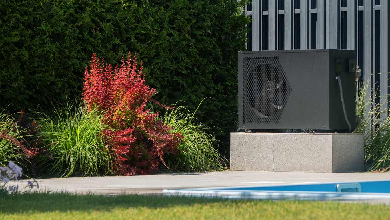 Installation moderne d'une pompe à chaleur pour piscine dans un jardin paysager