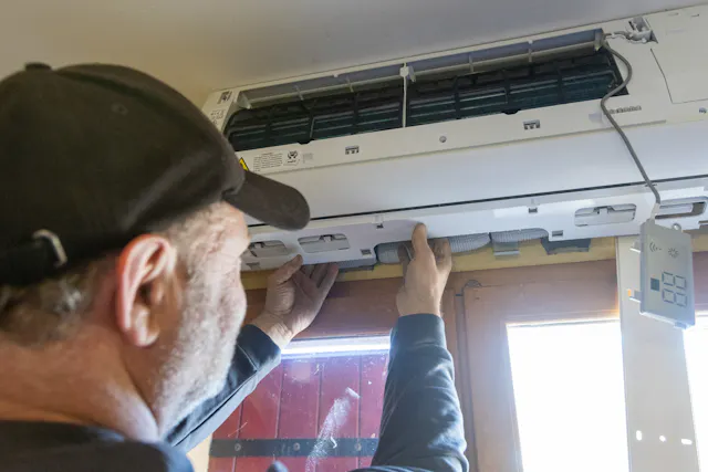 Technicien HomeServe installant une climatisation réversible dans un logement