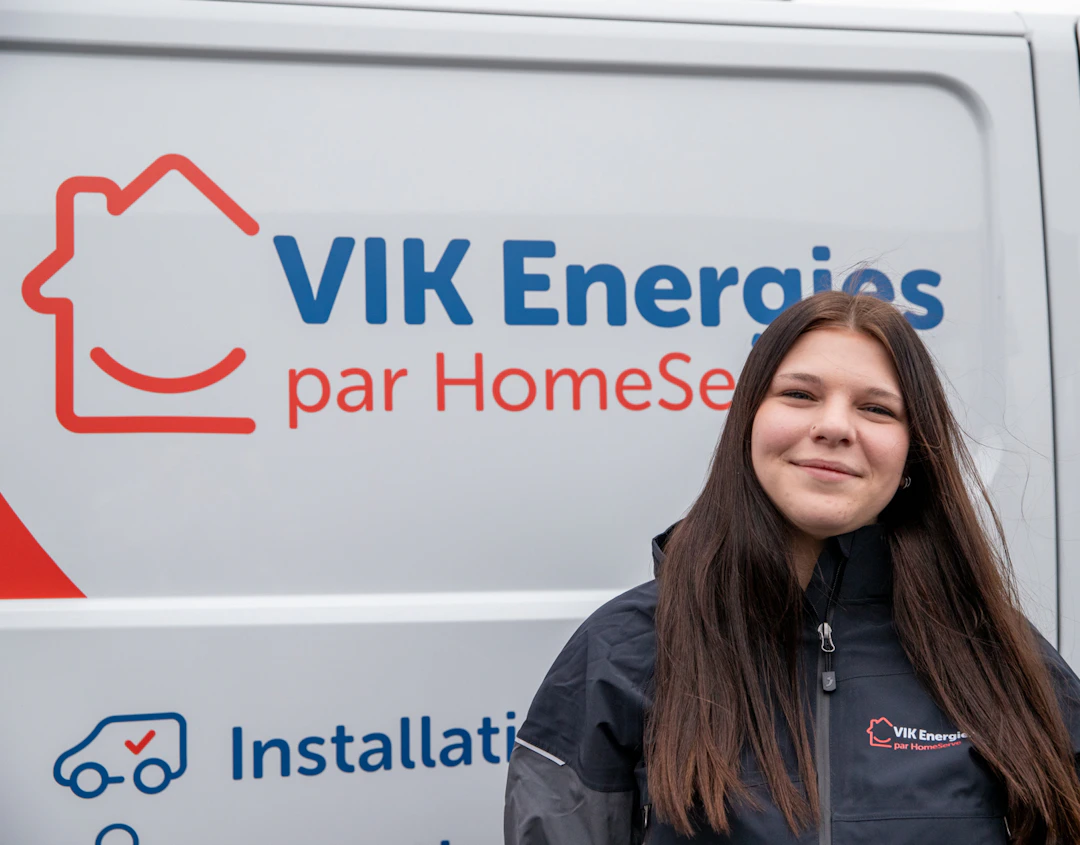 Une technicienne VIK Energies pose devant un camion de l'entreprise avant une intervention chez un client près de Carentan dans la Manche
