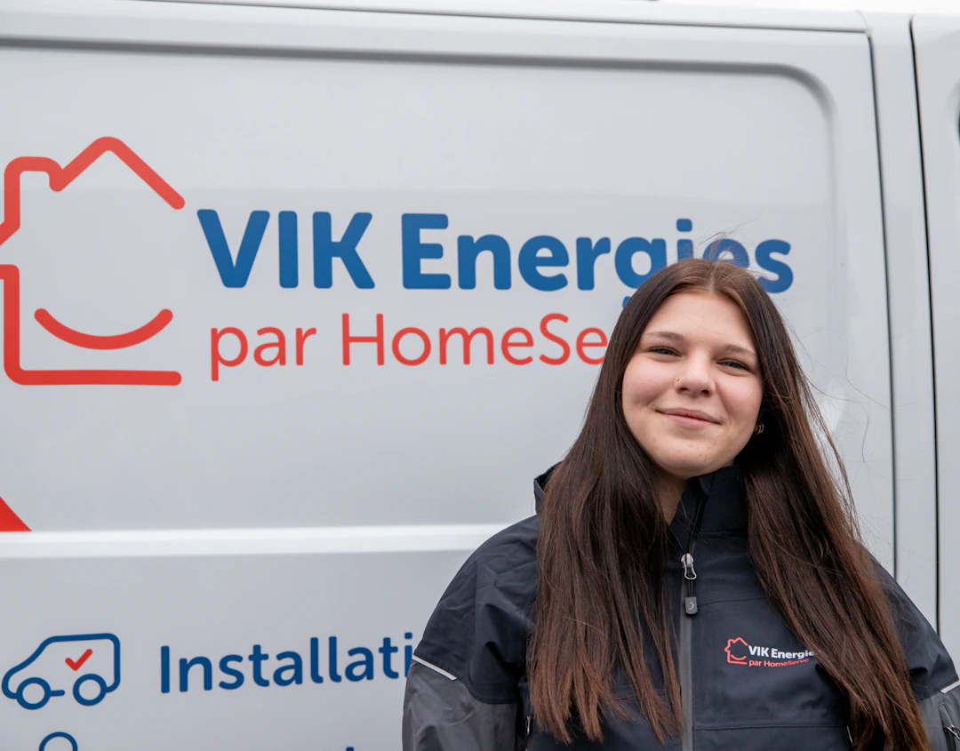 Une technicienne VIK Energies pose devant un camion de l'entreprise avant une intervention chez un client près de Torigny-les-Villes dans la Manche