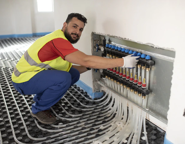 Un technicien, entrain de réaliser l'installation d'un plancher chauffant près de Bricquebec-en-Cotentin dans la Manche