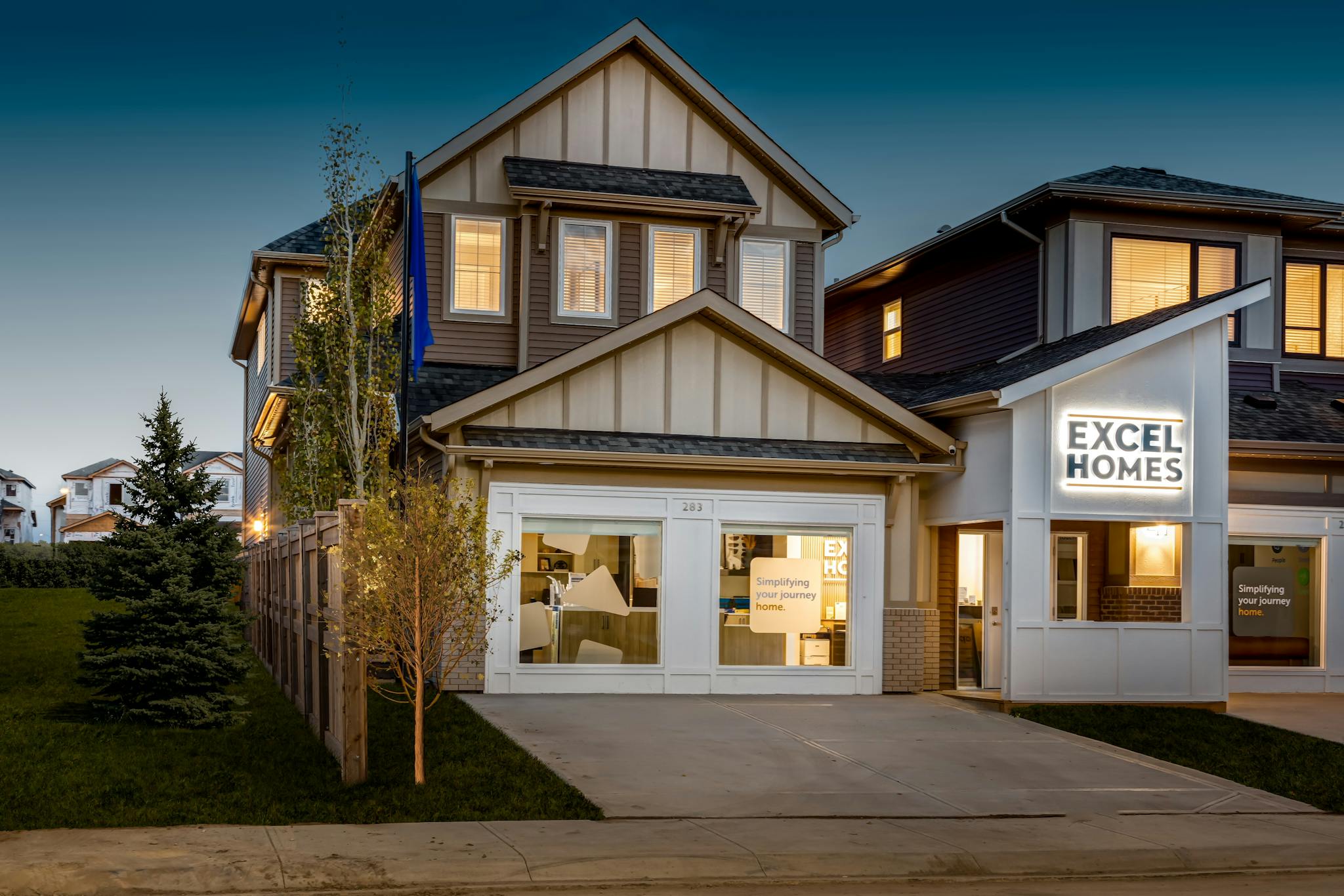 Showhome by Excel Homes, with a white garage door, under an evening sky