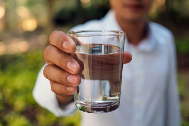 Customer Holding Fresh Glass of Homewater Filtered Product