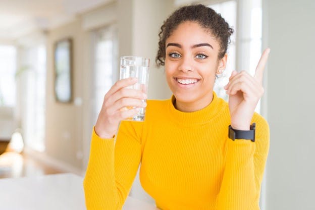 Woman Smiles as She Drinks Her Water
