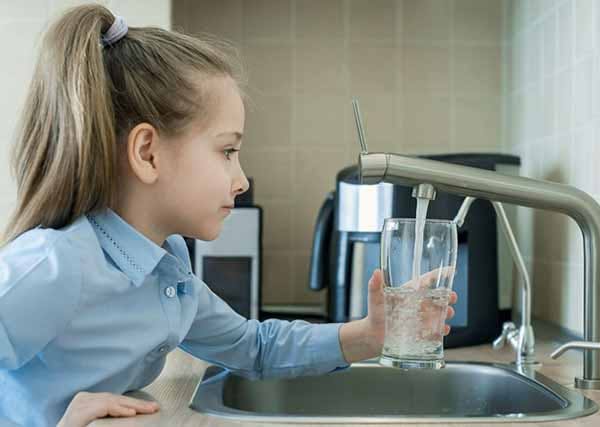 Young Girl Gets Fresh Glass of Tap Water Photo