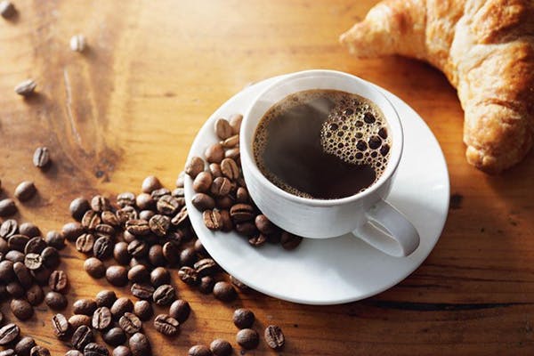 Hình ảnh bữa sáng cà phê nóng bên cạnh hạt cà phê