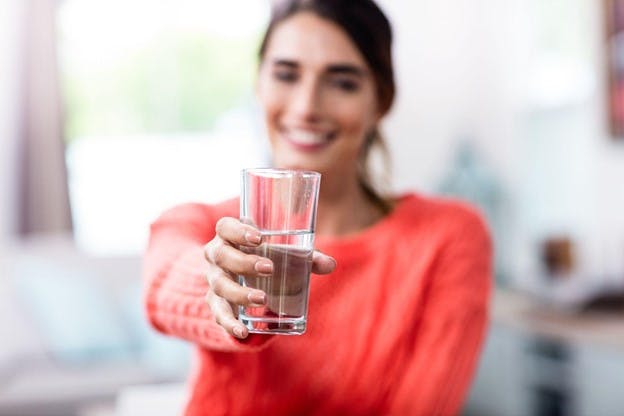 Lady Holds Up Fresh Glass of Filtered Water