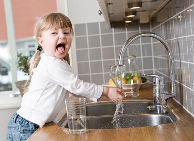 Child Washes Hands in Kitchen Sink