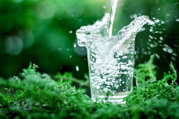 Glass And A Cup With Transparent Cool Clean Water On A Green Garden  Background Clean Water Health Food Industry Health Ecology Environmental  Protection Thirst Quenching Stock Photo - Download Image Now - iStock