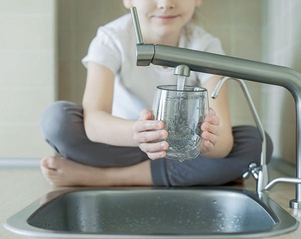 Child Fills Glass with Filtered Water for Better Taste