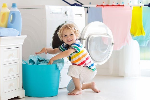 Young Boy in Room Plays with Laundry