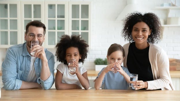 Family Drinks Filtered Water at Home and Smiles