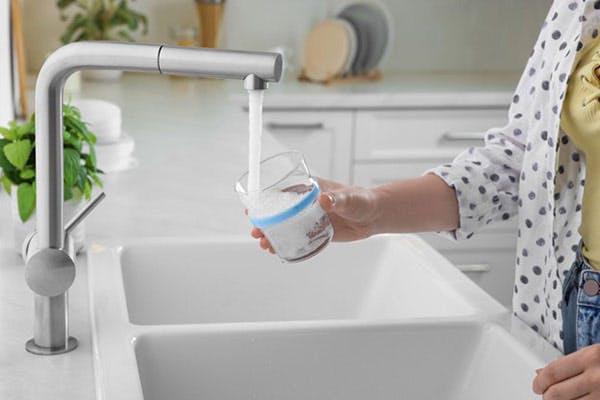 Lady Gets Cup of Water From Sink Filtered