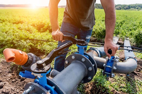 Man Installs Irrigation System Farm Field