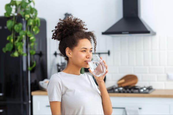 Woman Drinking Filtered Water in Glass