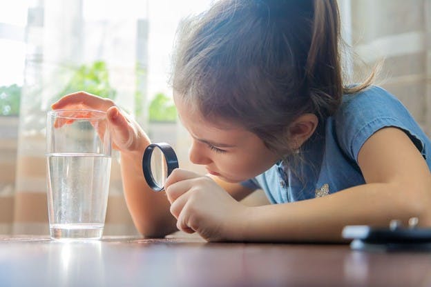 Girl Analyzes Glass of Water for Microplastics